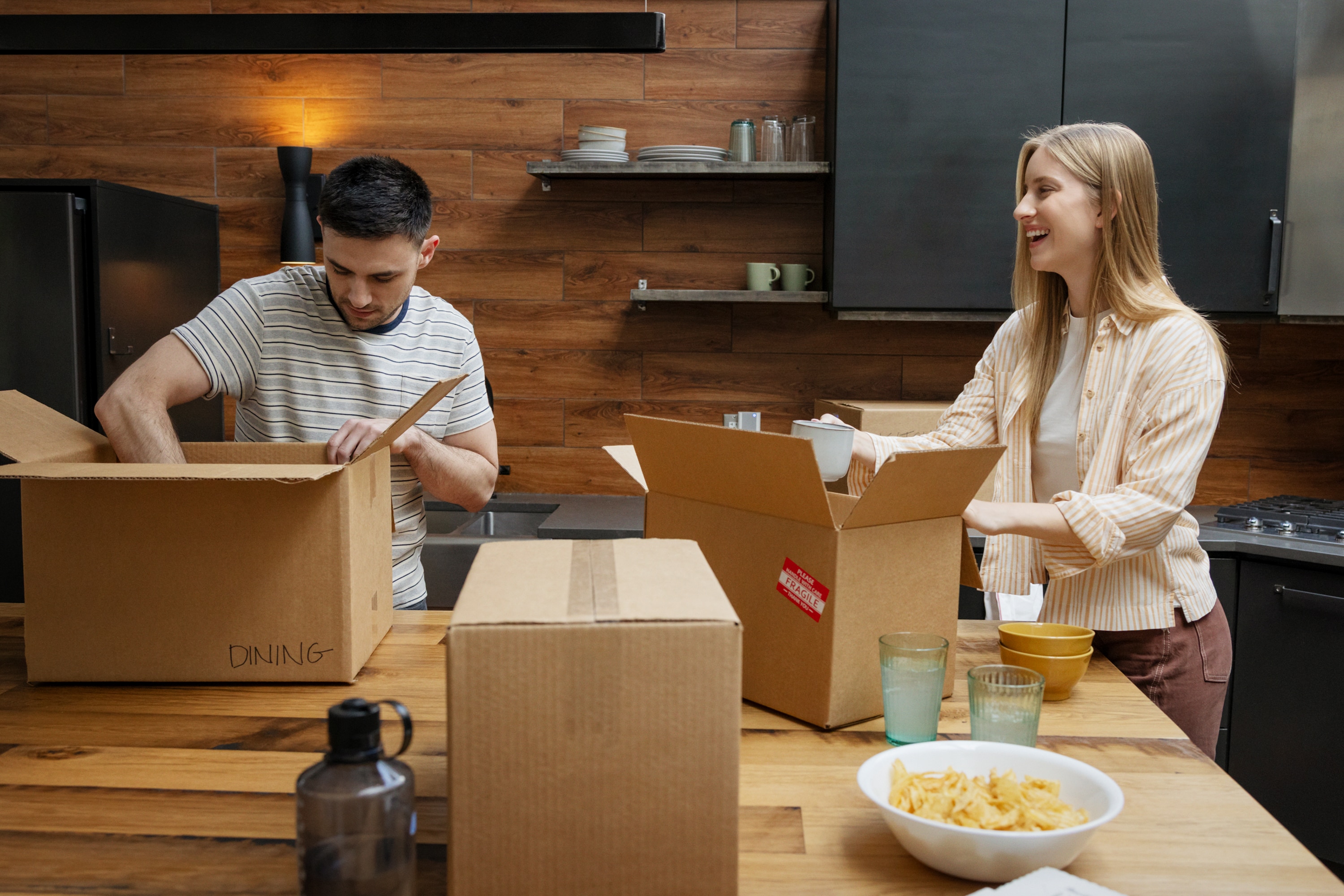 Male and female unpacking boxes in their kitchen