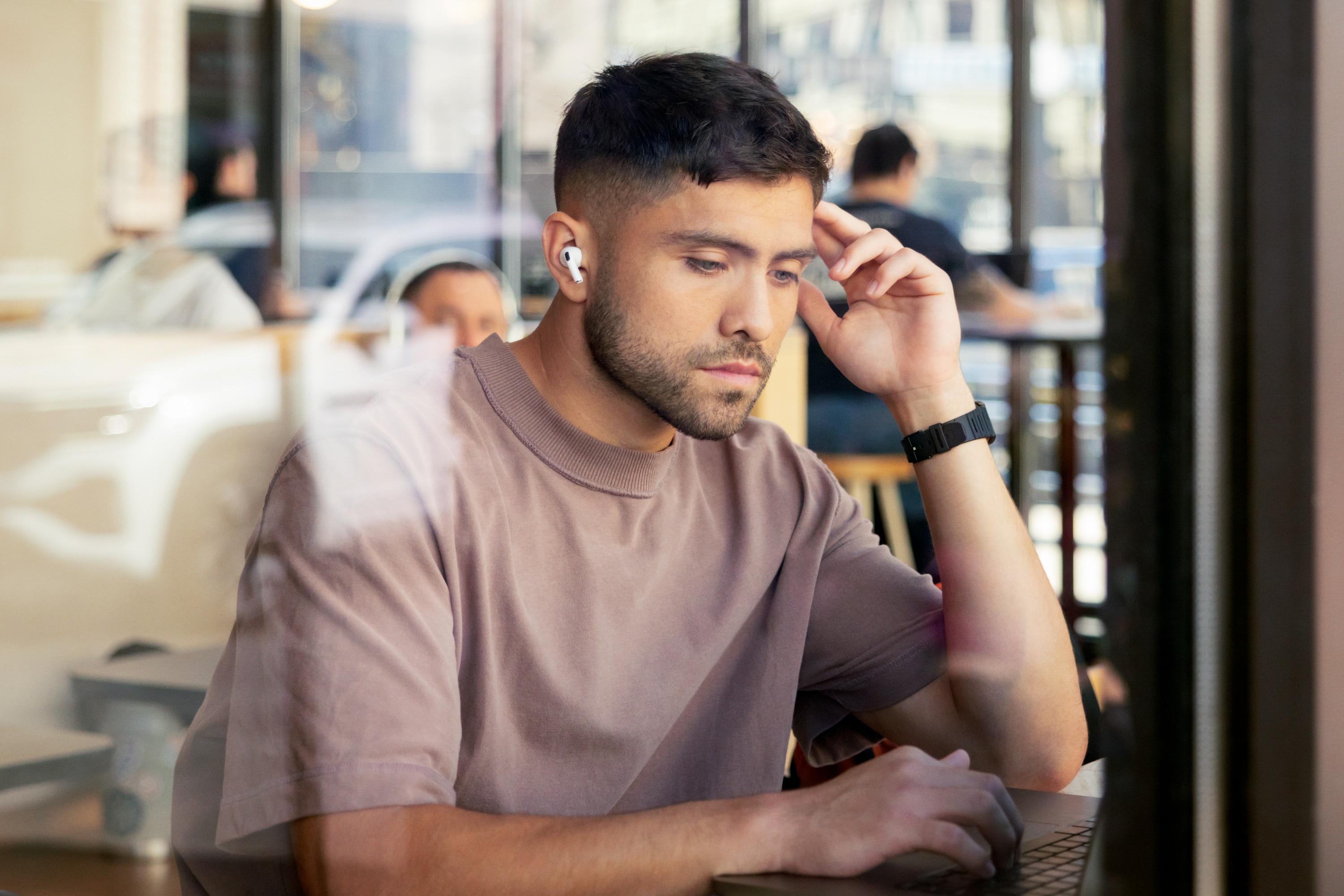 Male looking at a laptop in a cafe