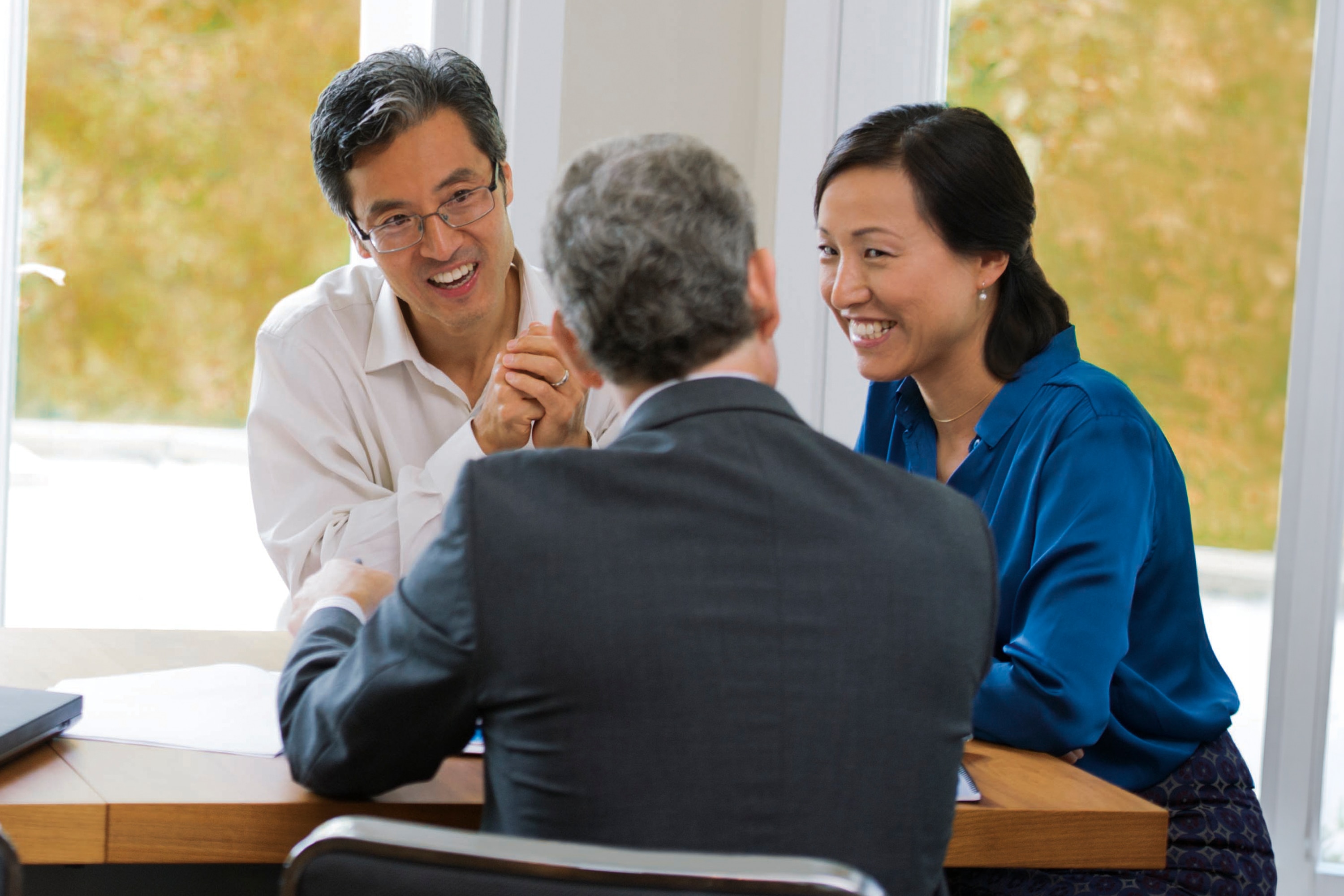 Group of three individuals in a meeting discussion